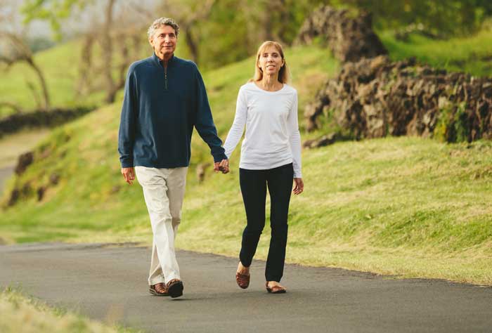 mężczyzna i kobieta idący drogą trzymając się za ręce